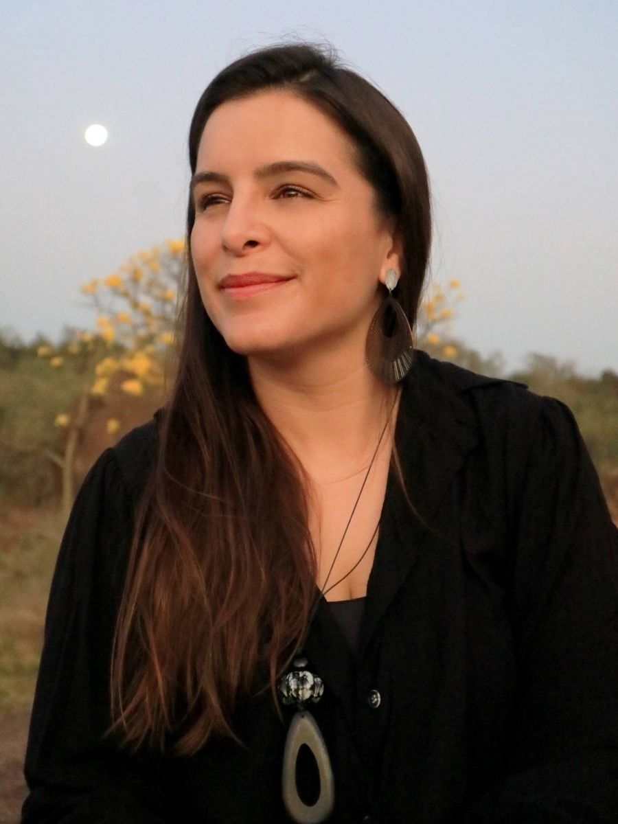Janaína Morelli, psicóloga, ao entardecer, olhando ao longe e sorrindo